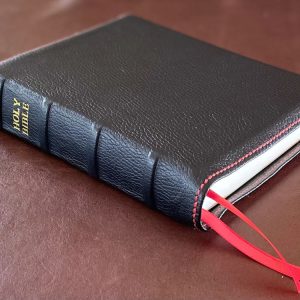 Black cowhide leather Thinline Bible with red perimeter stitching and two red ribbons